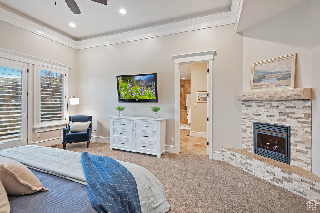 Bedroom featuring crown molding, light carpet, a fireplace, baseboards, and ensuite bathroom