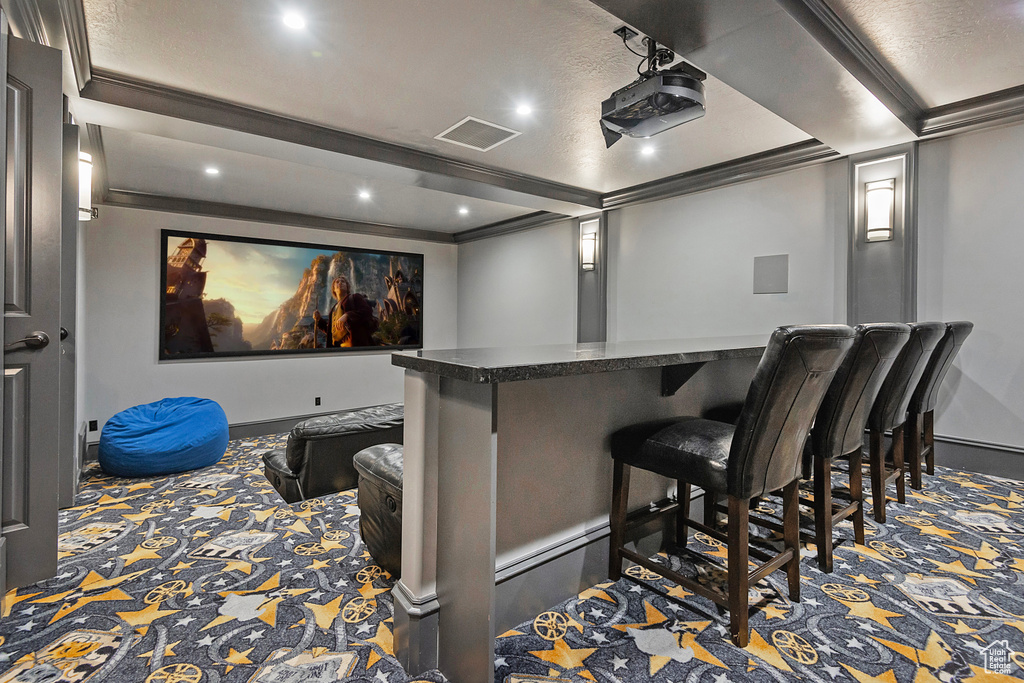 Home theater room featuring baseboards, carpet, recessed lighting, and a bar