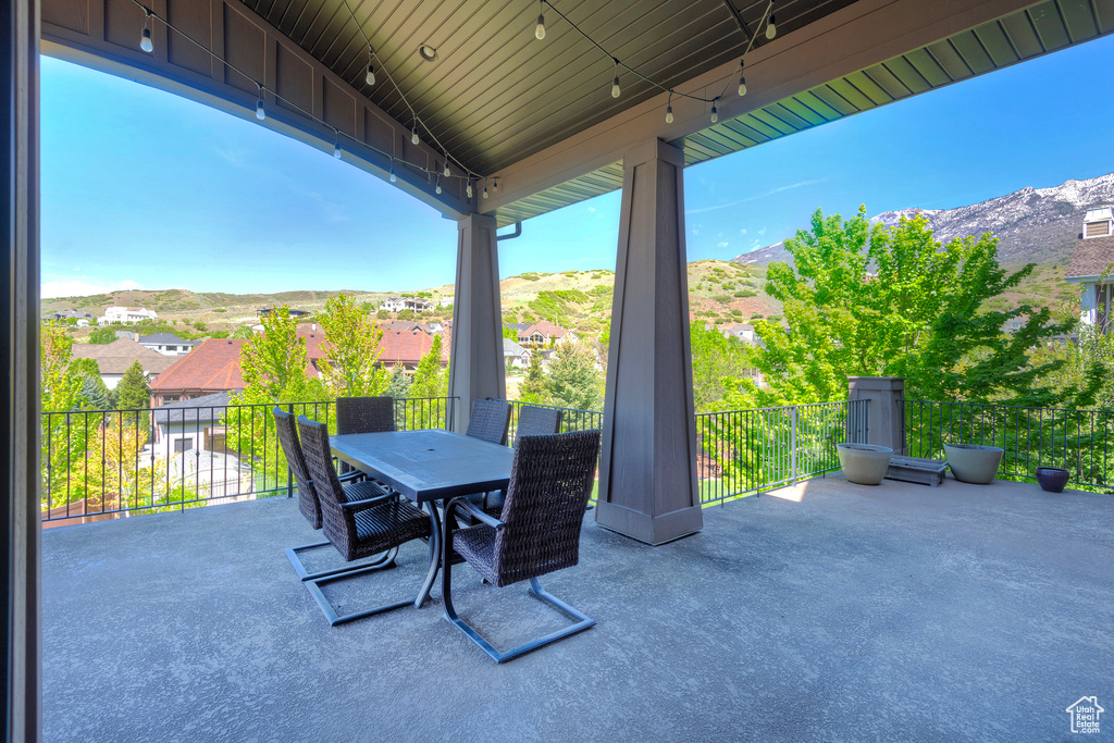 View of patio featuring a mountain view, outdoor dining area, and a balcony