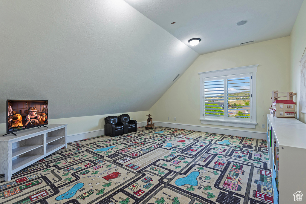 Additional living space featuring lofted ceiling, carpet floors, and baseboards