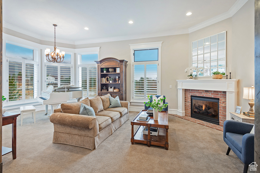 Carpeted living room featuring healthy amount of natural light, a brick fireplace, ornamental molding, a chandelier, and recessed lighting