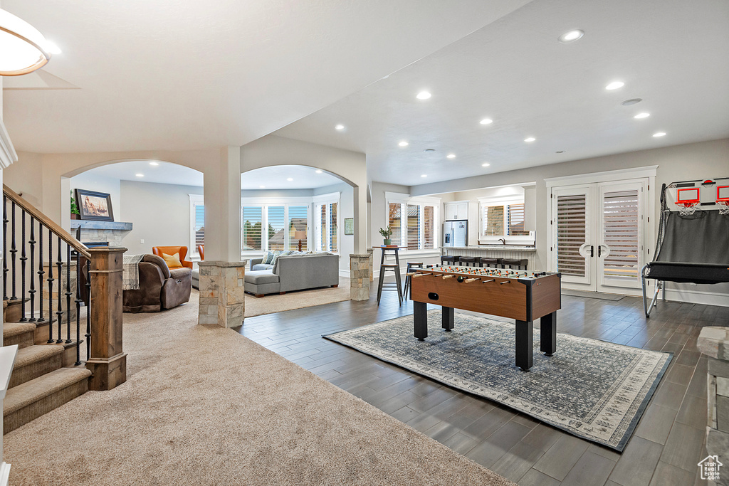Rec room featuring arched walkways, recessed lighting, and dark wood finished floors
