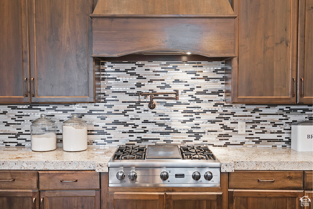 Kitchen featuring decorative backsplash, stainless steel gas cooktop, and light countertops