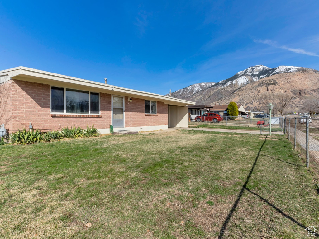 View of yard featuring a mountain view and fence