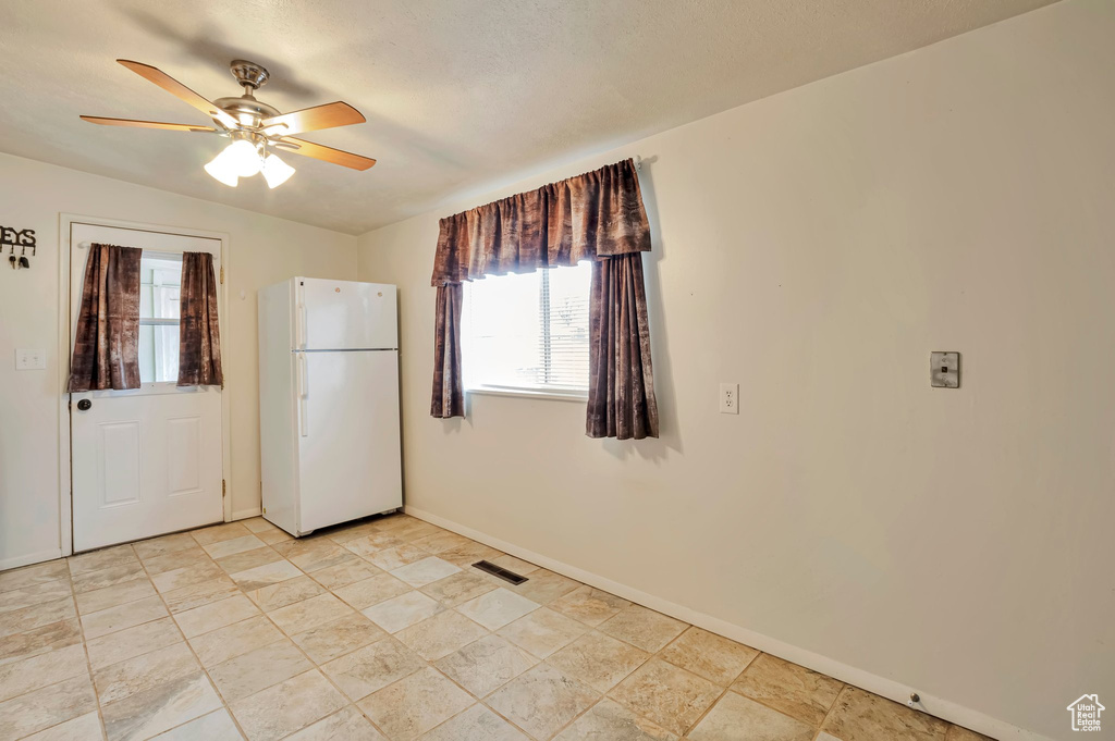 Spare room with visible vents, baseboards, and a ceiling fan