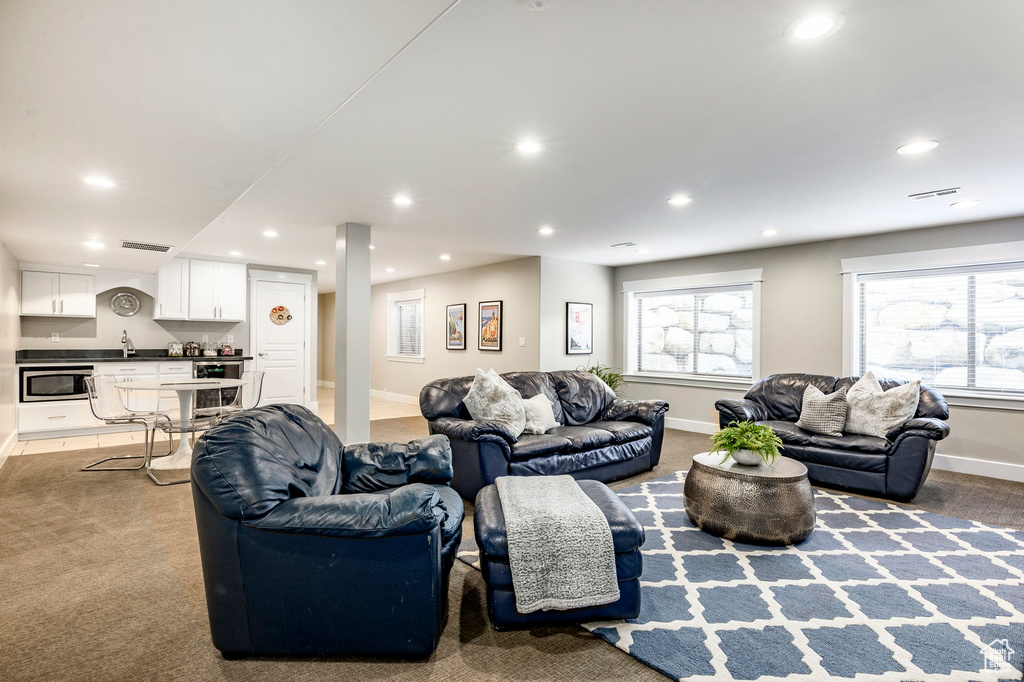 Carpeted living area with recessed lighting, baseboards, bar area, and healthy amount of natural light