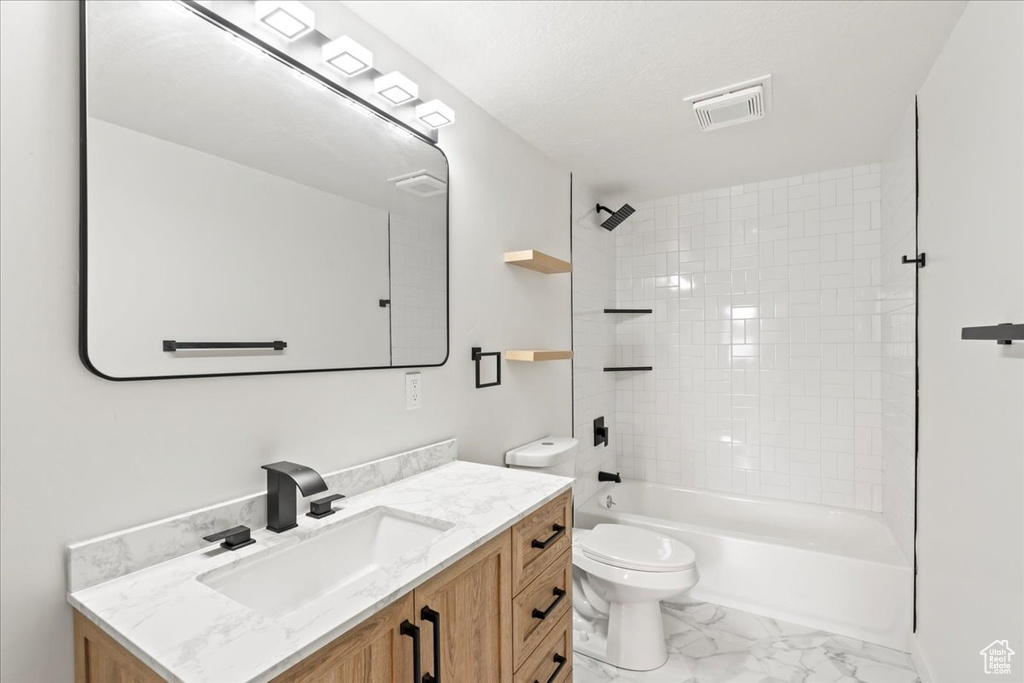 Full bath featuring visible vents, washtub / shower combination, toilet, marble finish floor, and vanity