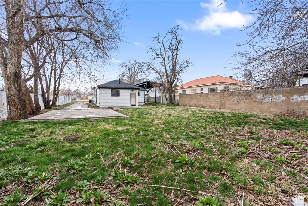 View of yard featuring a patio, an outbuilding, and a fenced backyard