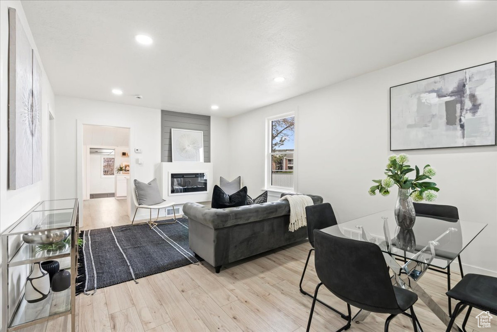 Living room featuring a glass covered fireplace, recessed lighting, and wood finished floors