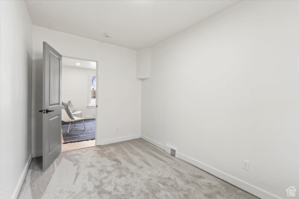 Empty room featuring visible vents, baseboards, and carpet