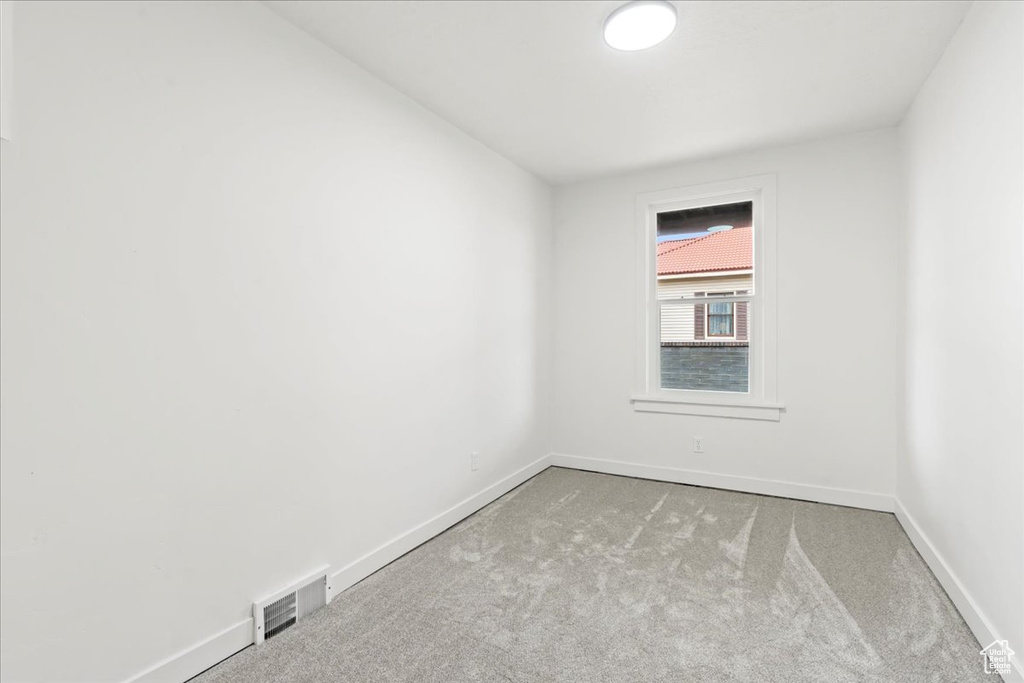 Spare room featuring visible vents, baseboards, and carpet