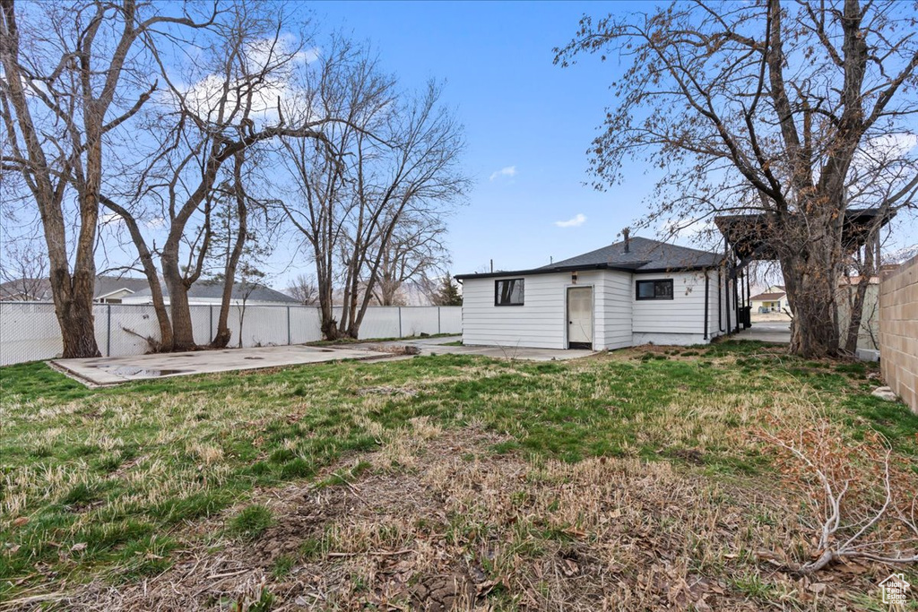 Back of property featuring a lawn, a fenced backyard, and a patio area