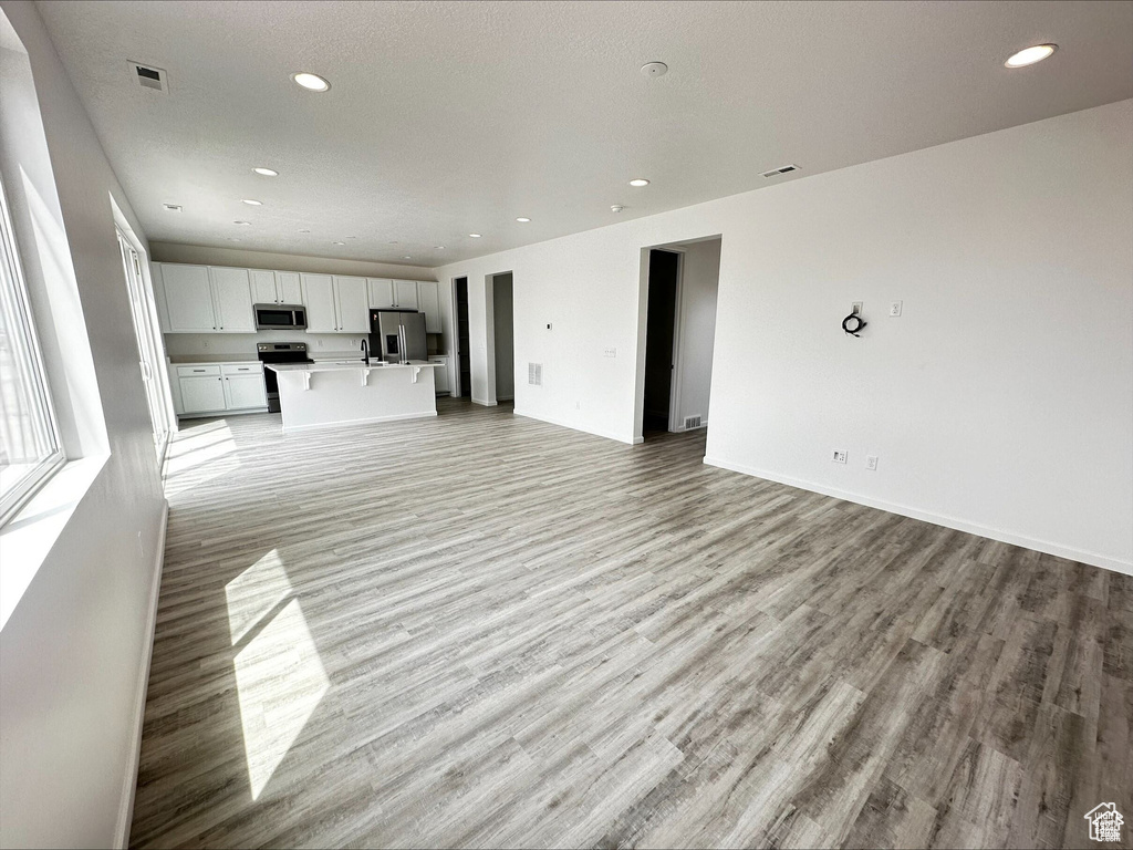 Unfurnished living room with visible vents, recessed lighting, baseboards, and light wood finished floors