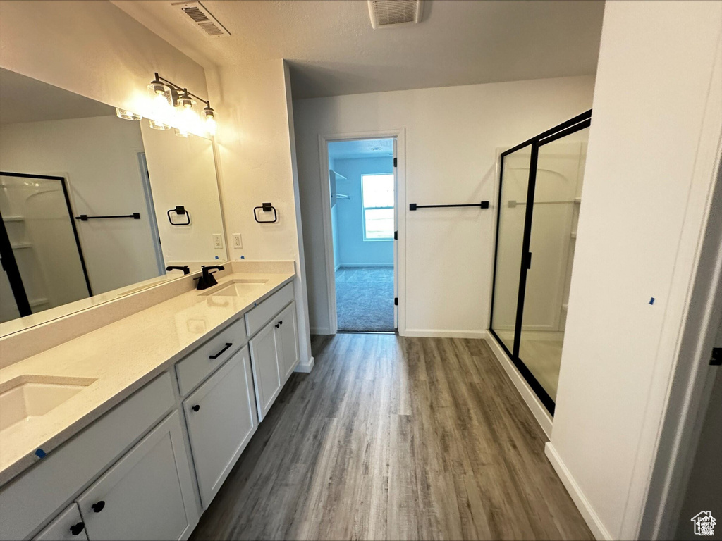 Bathroom featuring visible vents, a shower stall, and a sink