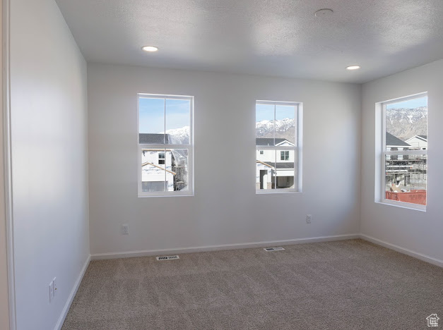 Unfurnished room featuring carpet floors, baseboards, a textured ceiling, and recessed lighting
