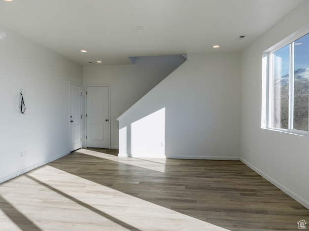 Unfurnished room with recessed lighting, wood finished floors, and baseboards