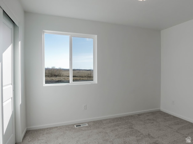 Carpeted empty room with baseboards