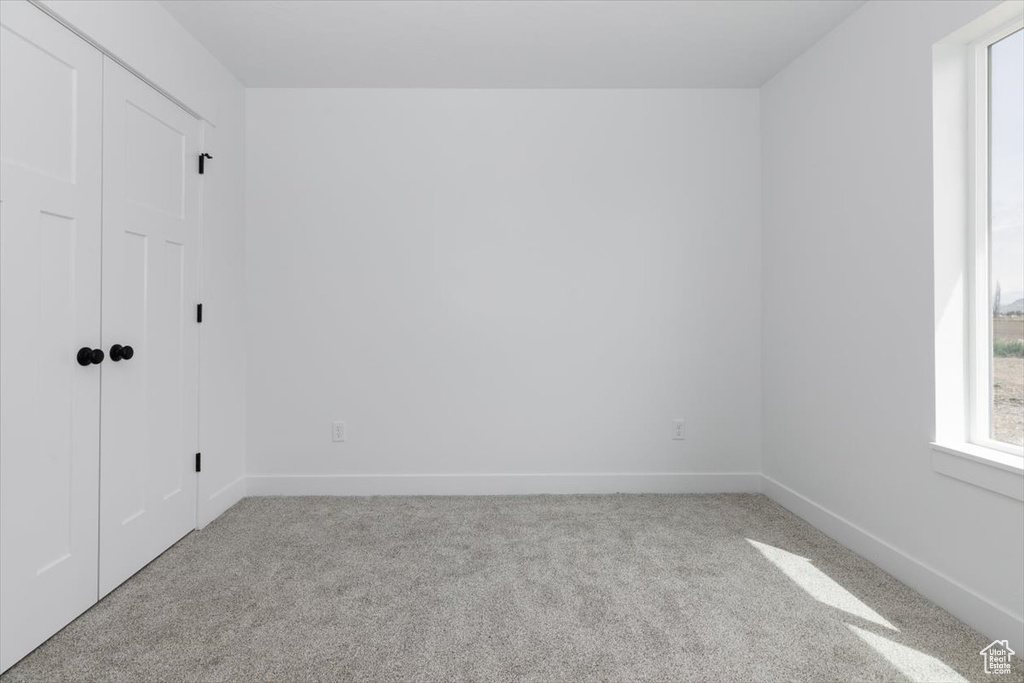 Unfurnished room featuring baseboards and light colored carpet