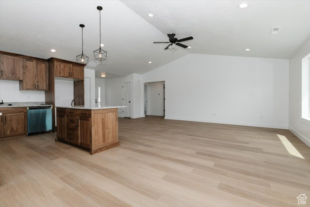 Kitchen featuring light countertops, vaulted ceiling, light wood finished floors, and dishwasher