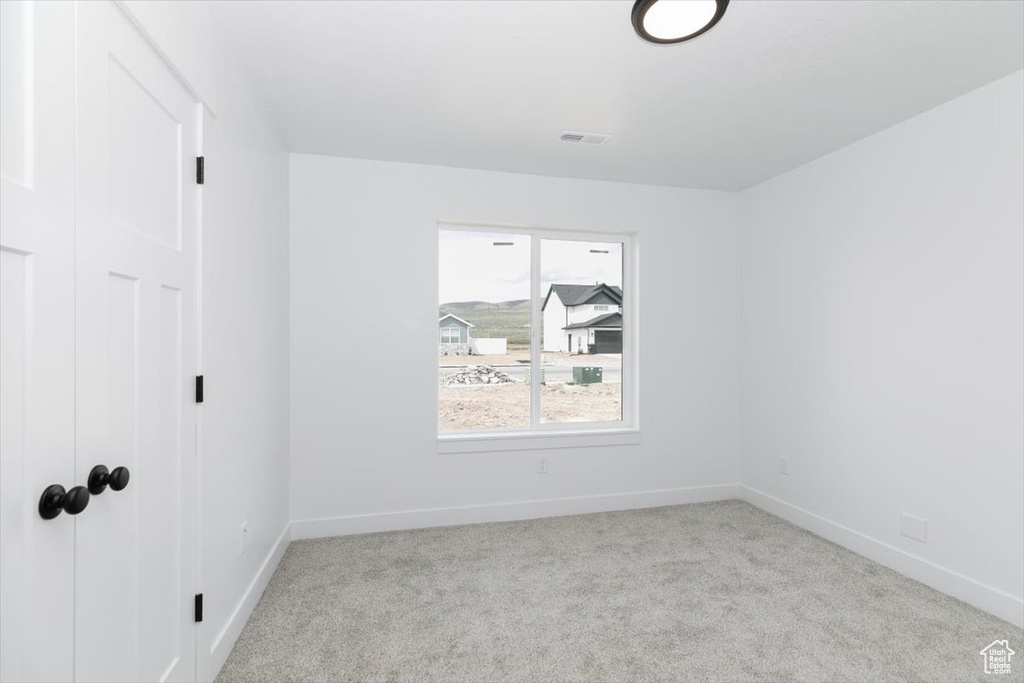 Spare room featuring carpet floors, baseboards, and visible vents