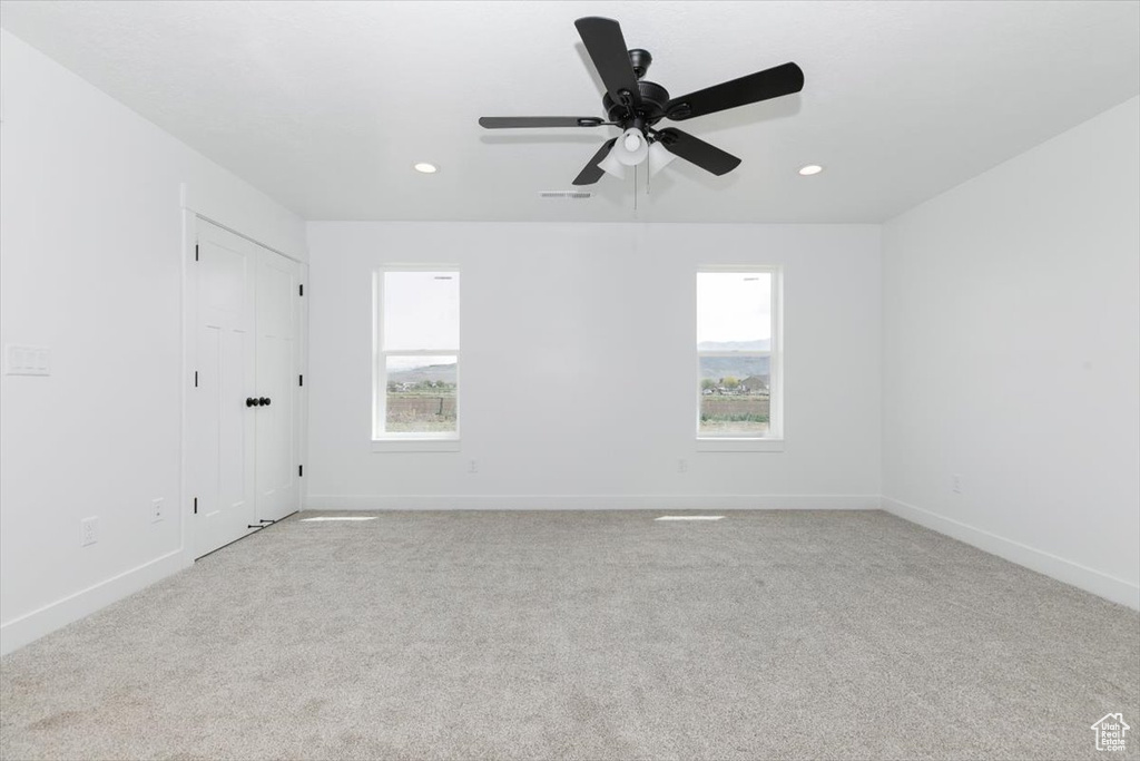 Carpeted spare room featuring baseboards, a ceiling fan, and recessed lighting