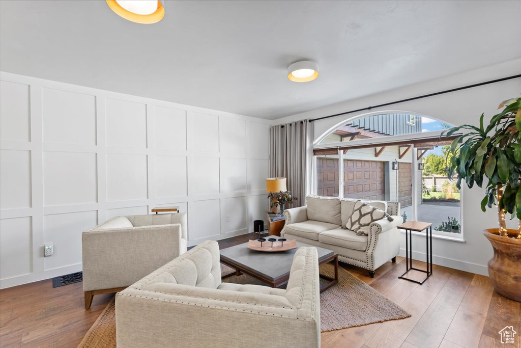 Living area featuring a decorative wall, visible vents, and light wood finished floors