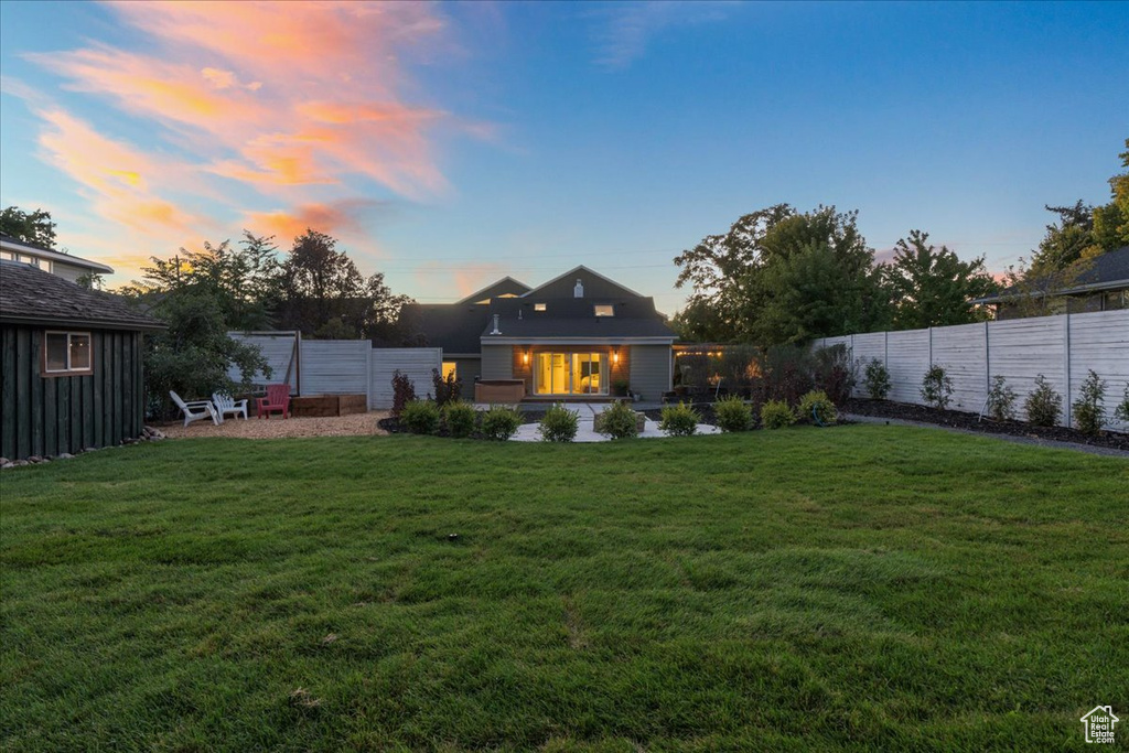 Back of property with a fenced backyard and a lawn