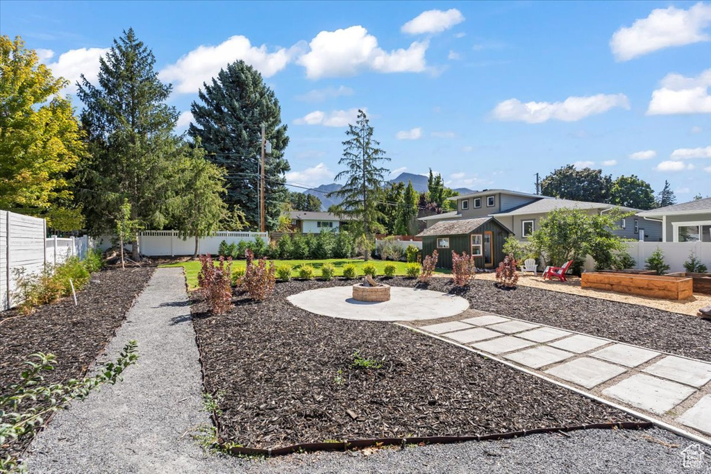 View of yard with a patio area, a vegetable garden, a fire pit, and a fenced backyard