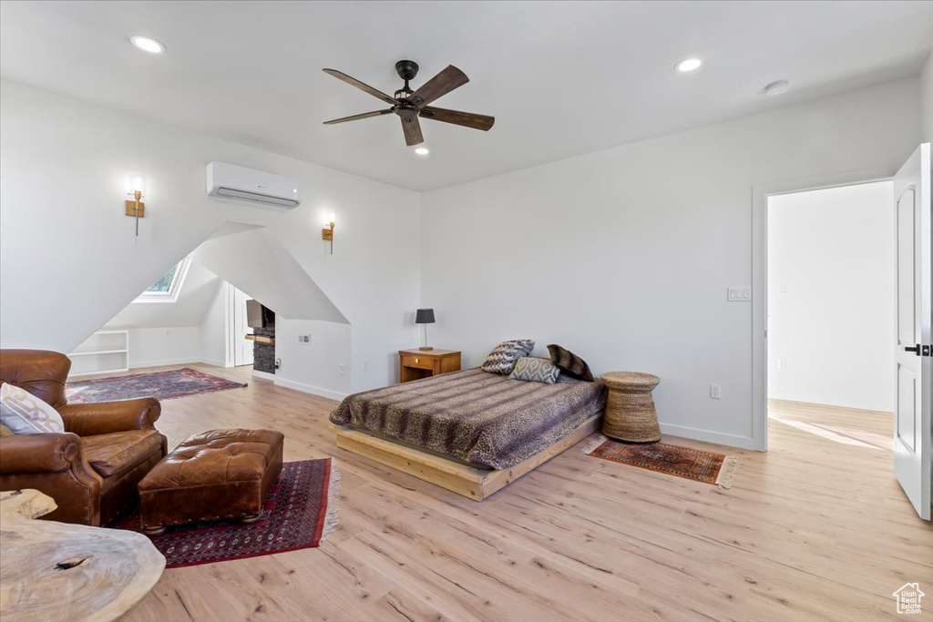 Bedroom featuring recessed lighting, wood finished floors, baseboards, and a wall mounted air conditioner