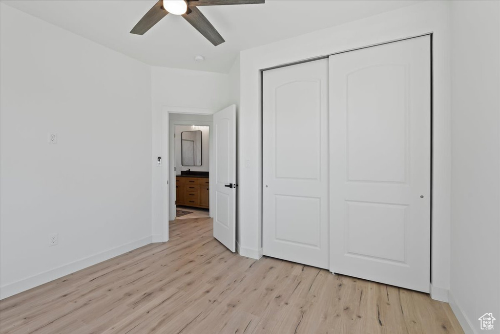 Unfurnished bedroom with a closet, baseboards, and light wood-style floors
