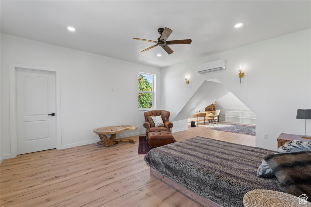 Bedroom featuring light wood finished floors, recessed lighting, baseboards, and a wall mounted air conditioner