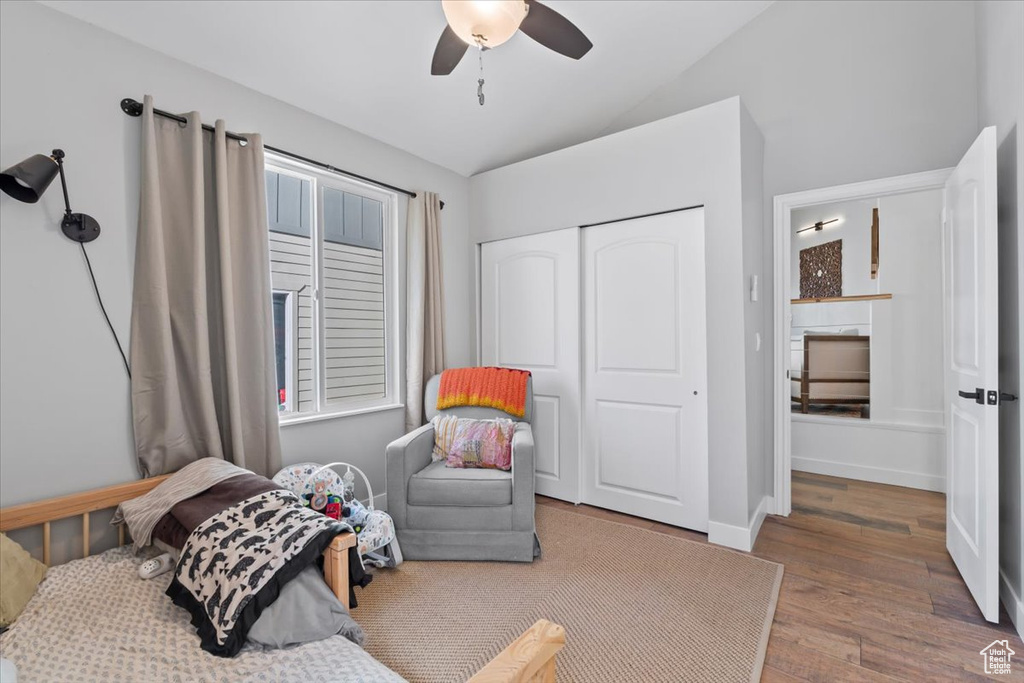 Bedroom with lofted ceiling, wood finished floors, a closet, baseboards, and ceiling fan