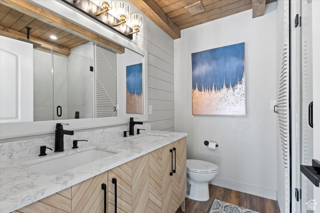 Bathroom featuring a stall shower, toilet, wooden ceiling, and a sink