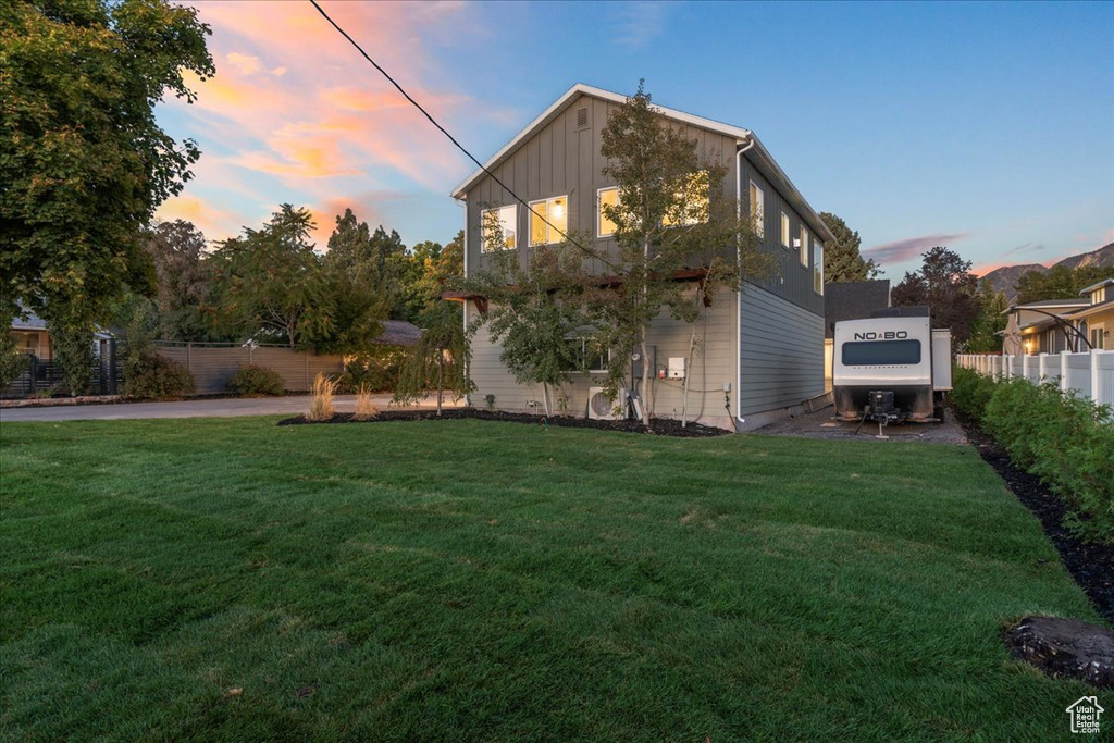 Exterior space with a yard, board and batten siding, and fence