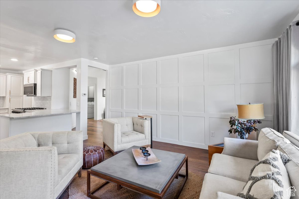 Living area with dark wood-type flooring and a decorative wall