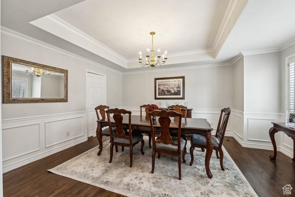 Dining room featuring a chandelier, a tray ceiling, and wood finished floors