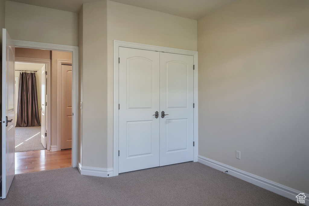 Unfurnished bedroom featuring carpet flooring, baseboards, and a closet