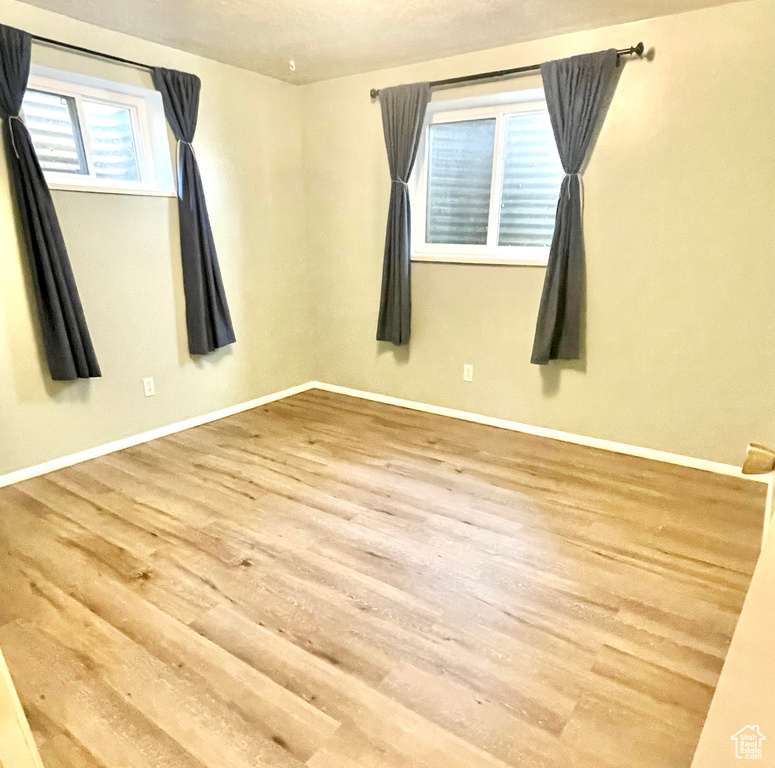 Unfurnished room featuring baseboards and wood finished floors