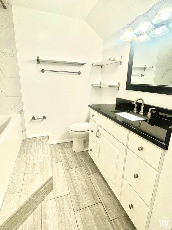 Full bathroom featuring vanity, baseboards, wood tiled floor, lofted ceiling, and toilet
