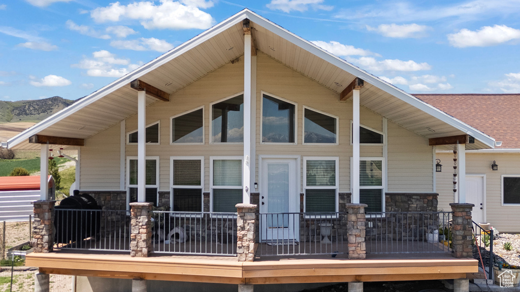 Back of house with stone siding and a mountain view