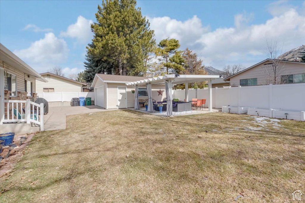 View of yard with a patio, fence, an outbuilding, and a pergola