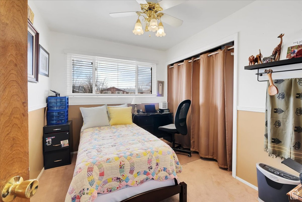 Carpeted bedroom featuring a ceiling fan