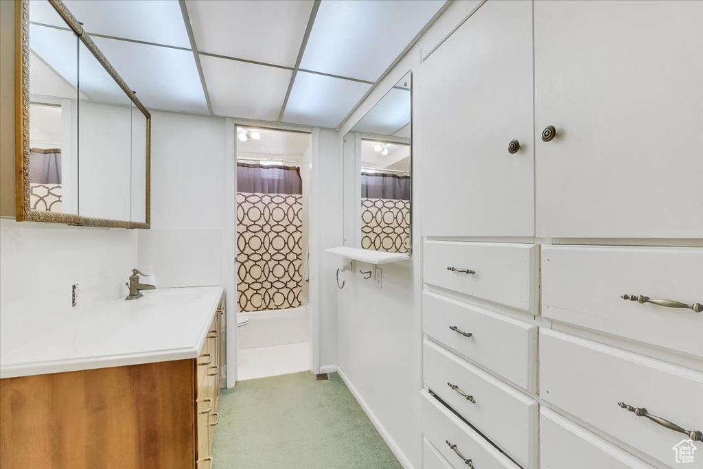Full bath featuring baseboards, shower / bath combo with shower curtain, and vanity