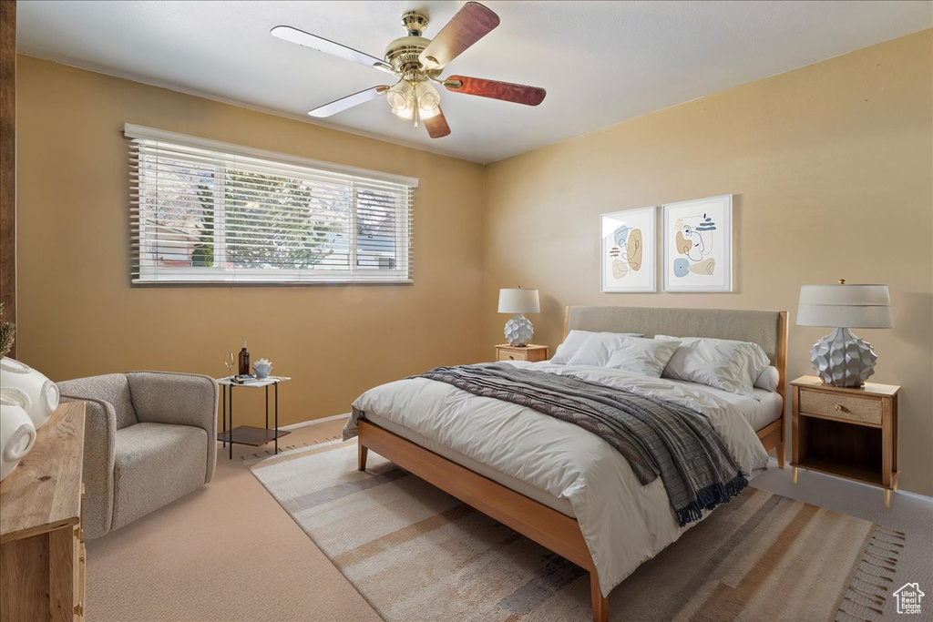 Bedroom with baseboards, light colored carpet, and ceiling fan