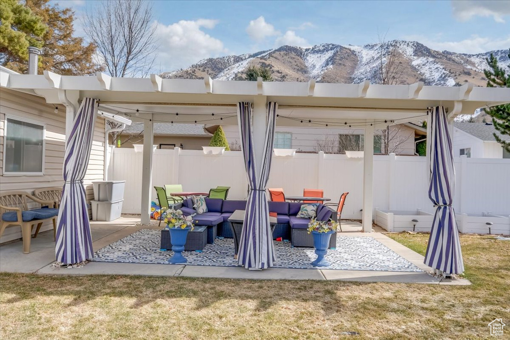 View of patio / terrace featuring an outdoor living space, a mountain view, and fence
