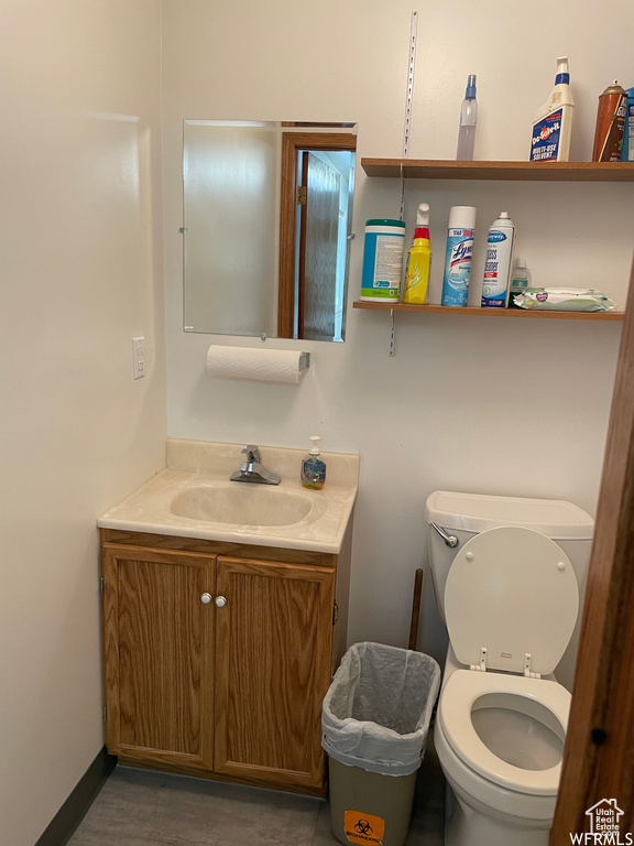Bathroom with toilet, wood finished floors, and vanity