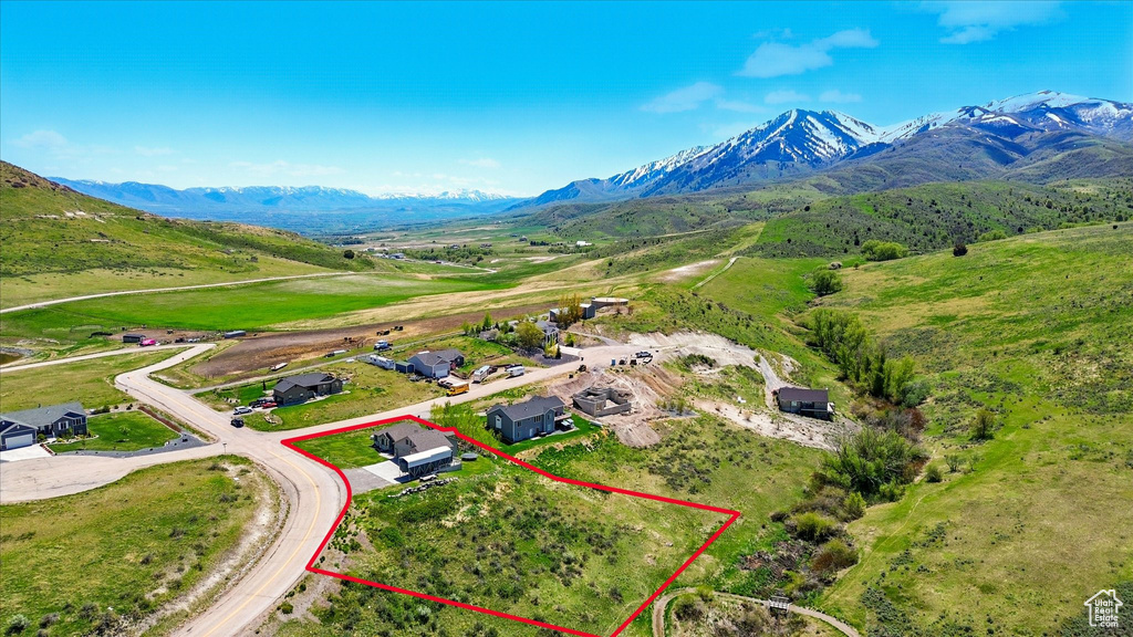 Aerial view of property and surrounding area with property parcel outlined and a mountainous background