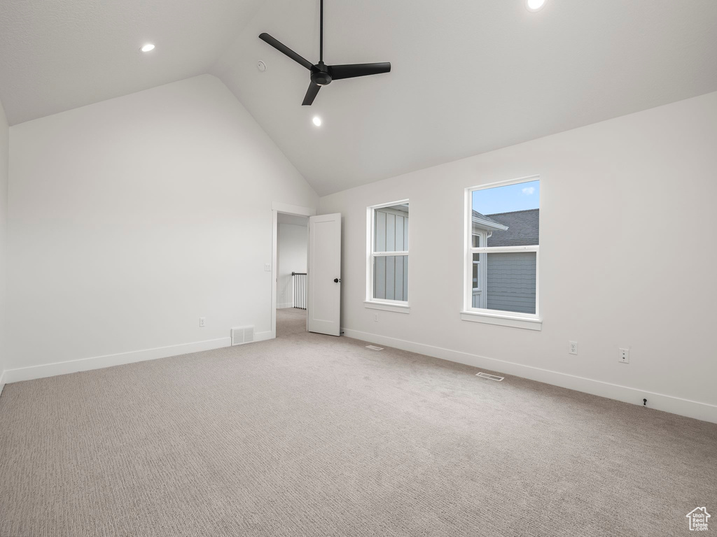 Spare room featuring visible vents, light carpet, baseboards, and a ceiling fan