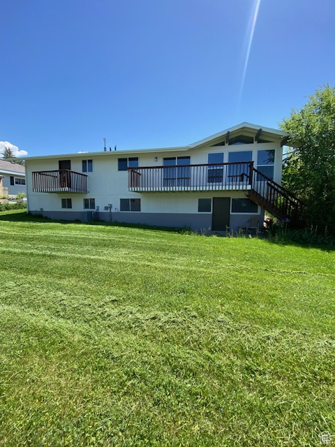 Rear view of property with a yard