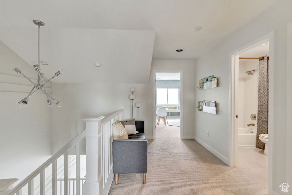 Corridor with light carpet, an upstairs landing, and baseboards